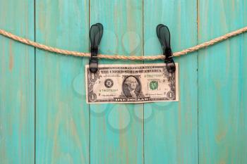One dollar hanging on a rope with clothes pins.Money laundering concept