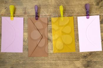 Four envelopes hang with  clips and rope on wooden  background