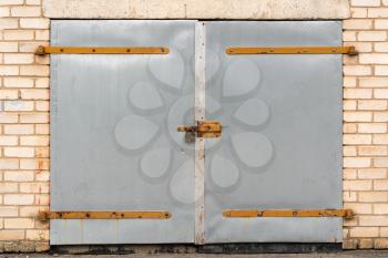 Metal garage door with padlock and hinges