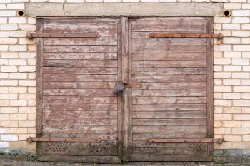 Old wooden garage door on brick wall