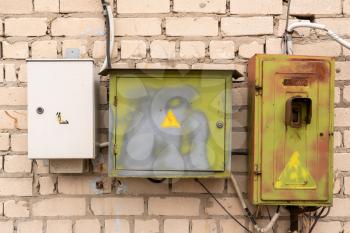 Set of connected electric boxes on the brick wall