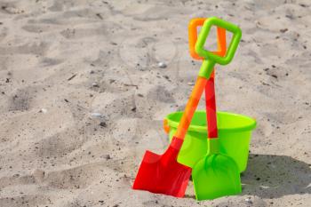 Plastic shovels and bucket on the beach sand