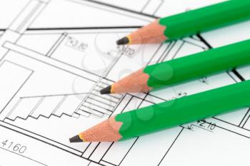 Three green pencils on architectural blueprint