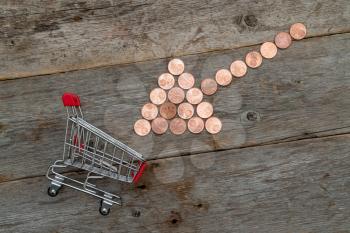  Combination of coin arrow and shopping cart on wooden background