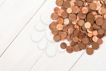 Pile of Euro cents on white wooden background.Copy-space.