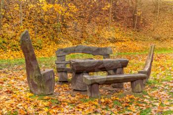 Outdoor wooden park furniture during the autumn season