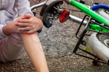 Child in pain after a bicycle accident. Kids safety concept