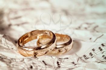 Golden wedding rings on old sheet music