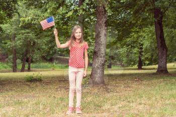 Patriotic holiday child with American flag for july 4th.