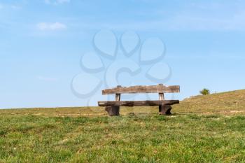 The empty wood bench in the public park under blue sky