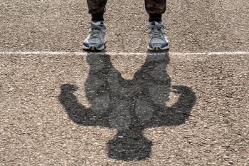 Shadow of man on a stadium running path. Sport concept