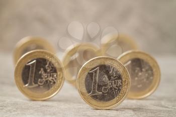 Several coins of One Euro on the stone background