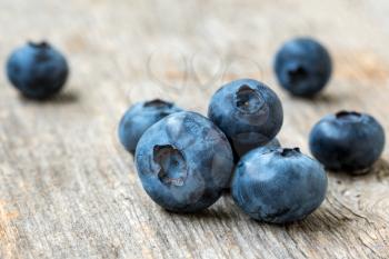 Blue heathberry (Vaccinium myrtillus) on rustic wood table background, close-up view