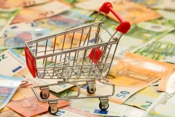 Consuming concept with shopping cart and euro currency