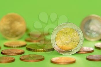 Euro coins in the pile on green background