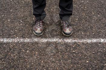 Man standing against white line on a road. New start, new life concept