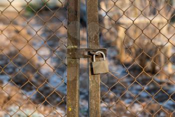 Old wire fence door with padlock