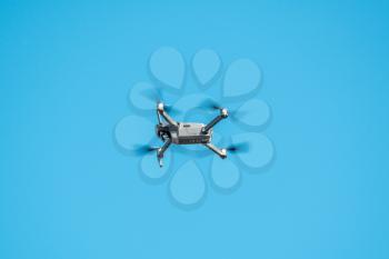 Drone quadcopter with digital camera on blue sky background