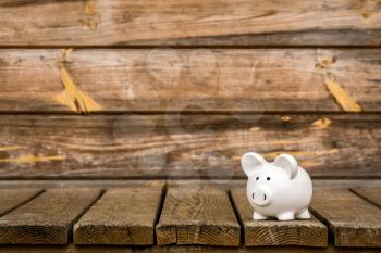 Piggy bank on the weathered wood background. Savings concept. Copy space.