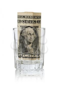 Glass for alcohol with one dollar inside. The concept of alcoholism and a lot of money on alcohol.