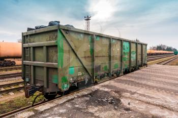 Unloading bulk cargo from railway wagon on high railway platform