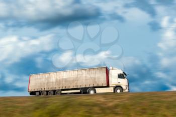 Truck on the road motion blur. Truck with container on highway, cargo transportation concept.
