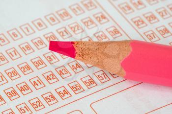 Closeup of lottery ticket and pink pencil