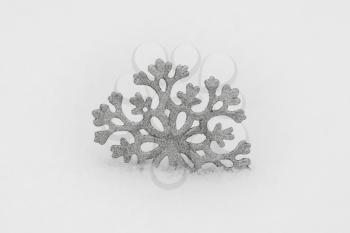 Christmas decoration. Beautiful silver snowflake on real snow outdoors. Winter holidays concept