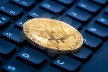 Bitcoin lying on computer keyboard , symbol of electronic virtual money and mining cryptocurrency concept. 
