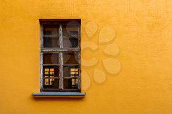 Old yellow house facade with wooden window. Copy space.