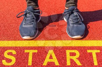 Legs in blue sneakers top view. Feet at the start line. Run sport concept. 