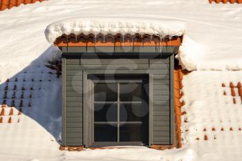 Dormer on a roof under a layer of deep snow