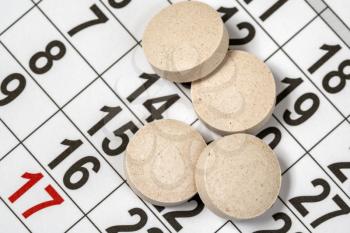Close up of medical pills on a calendar. Medication plan, schedule, list or calendar concept.