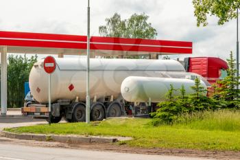 Tanker gas truck delivering fuel at service station 