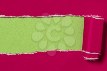 Pink torn paper to reveal green panel ideal for copy space