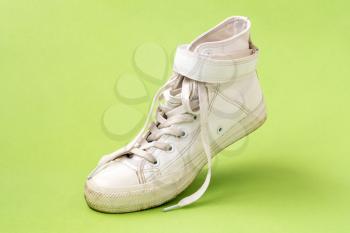 White leather shoe on the green background