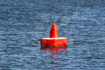 Red inflatable buoy on the blue sea. A buoy is a floating device that can have many purposes.