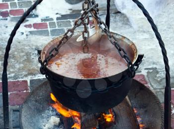 Copper with soup on fire in winter time