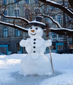 Snowman in the city under the trees