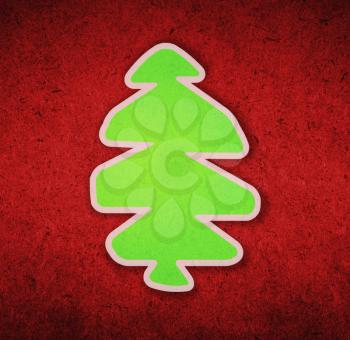 Green christmas tree on red paper surface