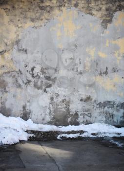 Stone wall and asphalt with snow