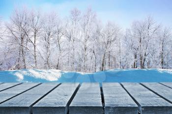 Snowdrift near frozen wooden path in winter on sunny day