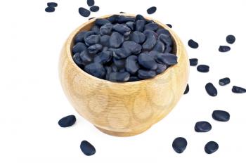 Black beans in a wooden bowl and on the table and isolated on a white background