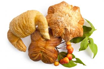 Croissant and two buns with a sprig of wild apples and green leaves isolated on white background