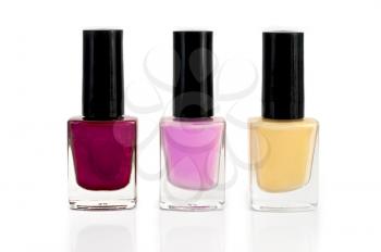 Three bottles with yellow, purple and pink nail polish isolated on white background