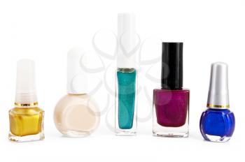 A number of different bottles with colored nail polish is isolated on a white background