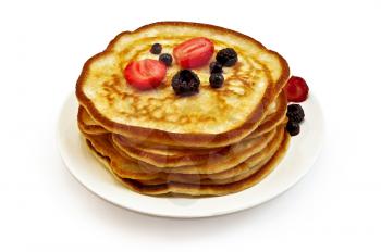 A stack of pancakes on a plate with strawberries, blackberries and blueberries isolated on a white background