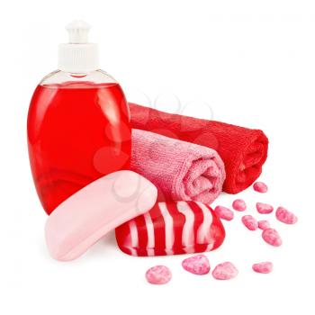 Red liquid soap in a bottle, solid red striped and pink soap, bath salt, two towels isolated on white background