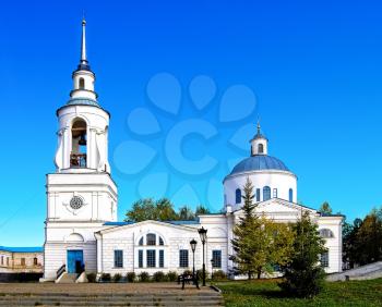 Snowy the Transfiguration Cathedral of St. Nicholas Monastery in the background of blue sky and yellow-green trees (Verhoturie city of Sverdlovsk Region)