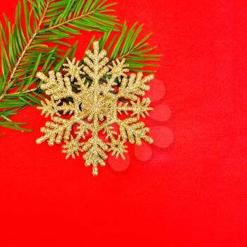 Christmas golden snowflake, spruce branches on a background of red silk